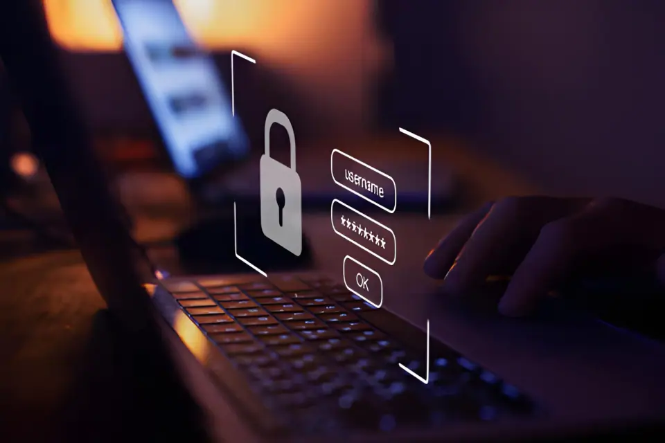 A hand on a laptop beside a floating sign-in prompt with a padlock, username and password fields, and an OK button